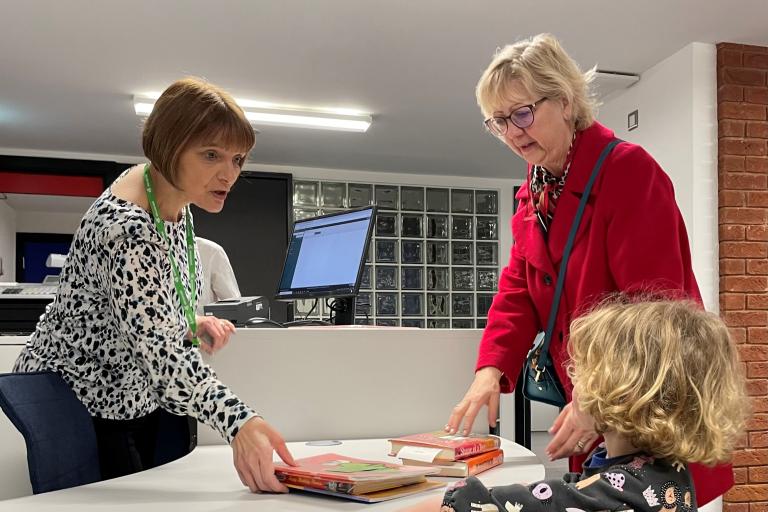 Councillor Zoe Nolan helps a three year old library customer borrow a book