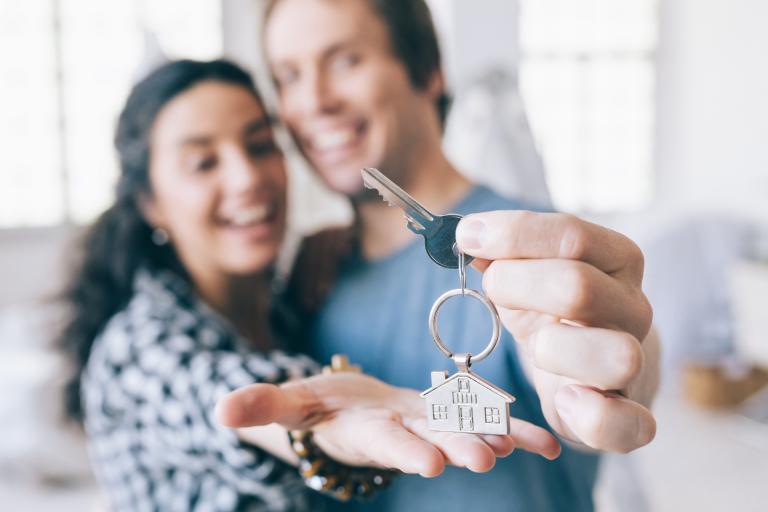 Couple holding set of keys to new home