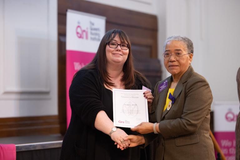 Sue Webb receiving her award from Dame Elizabeth Anionwu