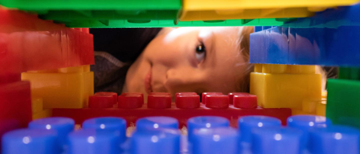 Boy peeking through a tunnel of building bricks