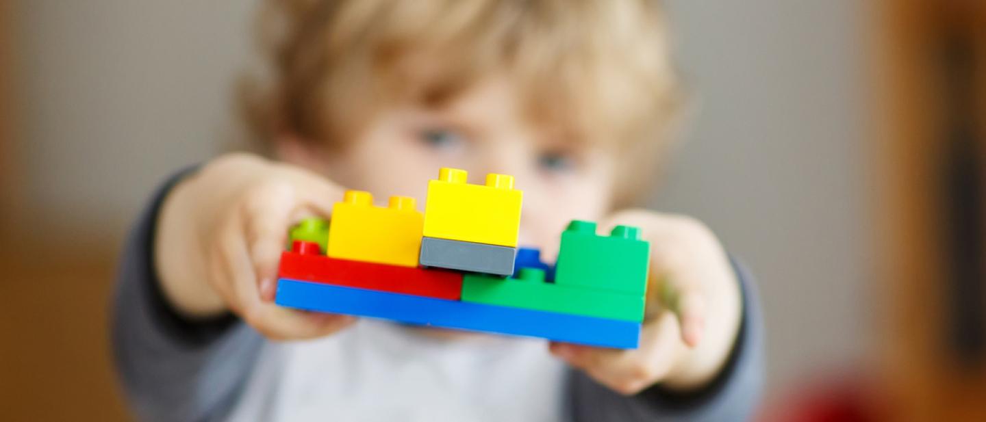 Child holding up some building bricks