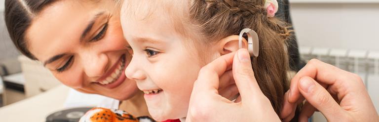 Girl receiving a hearing aid