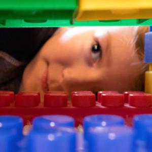 Boy peeking through a tunnel of building bricks